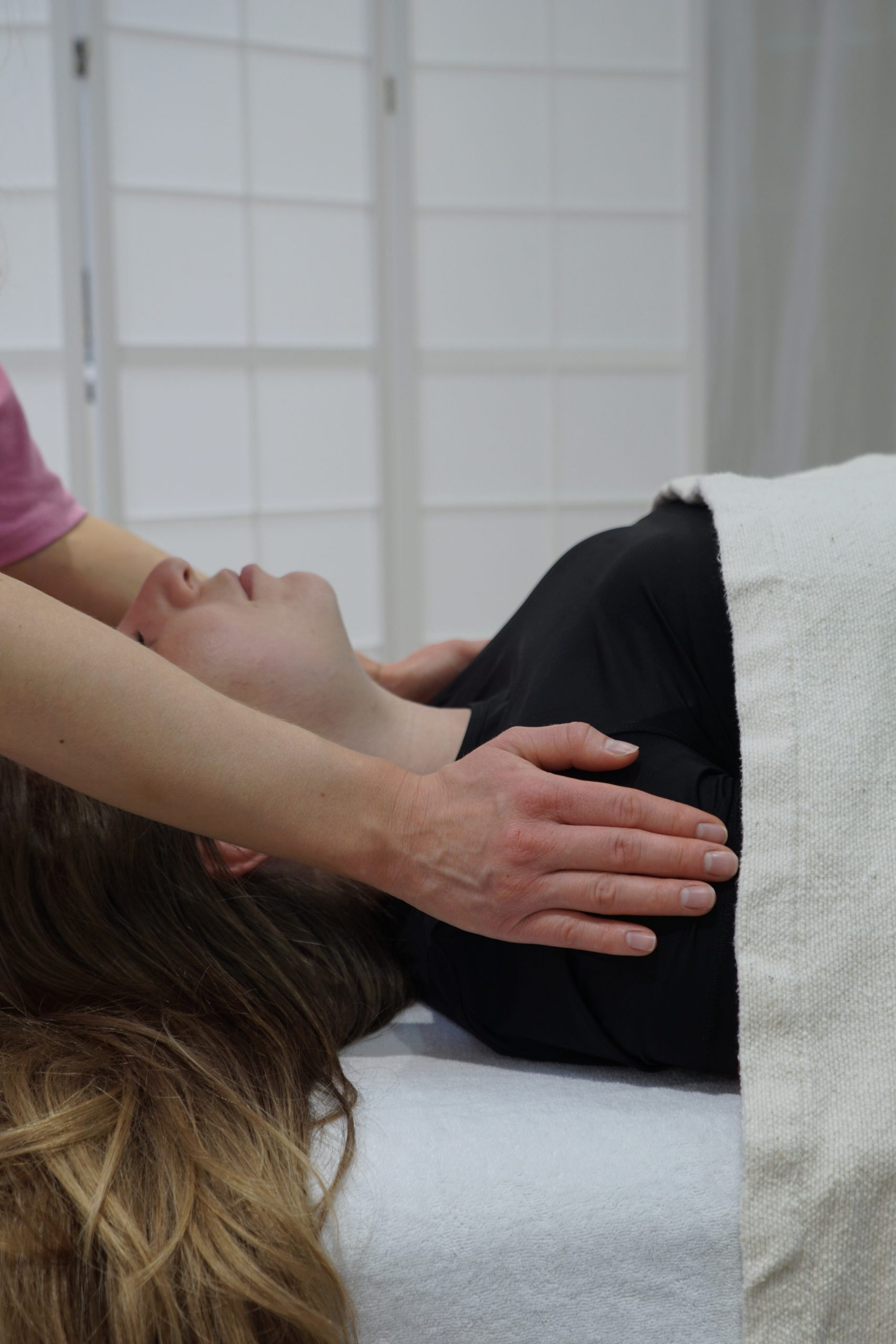 Reiki Session zur Entspannung im Oberkörper bei einer liegenden Frau